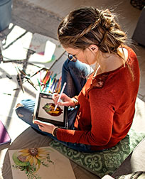 graphic designer illustrating image on tablet.