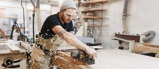 carpentry student using electric wood plane.