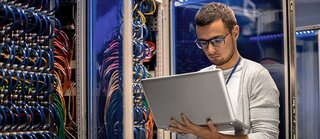 IT professional working on cable network in server room.