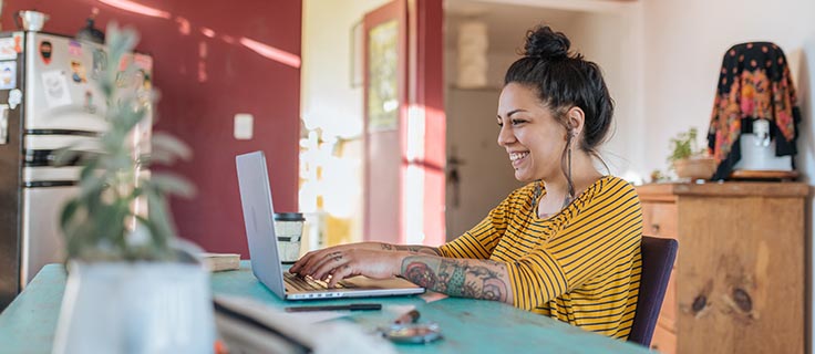 student working on laptop in dining room.