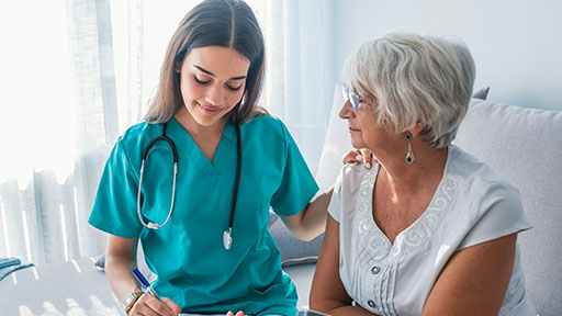 home health aide assisting an elderly patient.