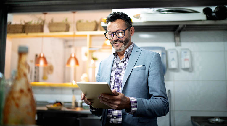 restaurant manager reading notes in kitchen.