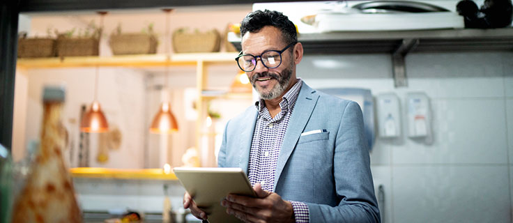 restaurant manager reading notes in kitchen.