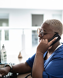 medical administrative assistant on phone at desk.