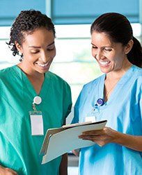 two medical assistants reading charts