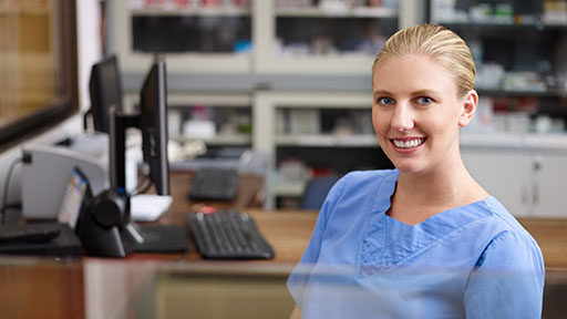 medical assistant sitting at her desk and smiling.