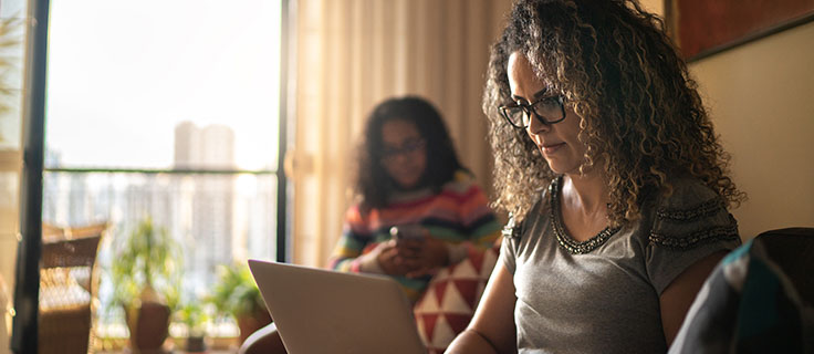 woman using laptop in living room.