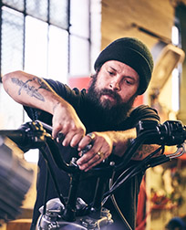 motorcycle repair technician working on handlebars.