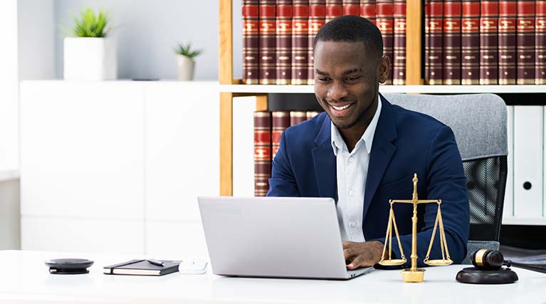 paralegal using laptop at desk.