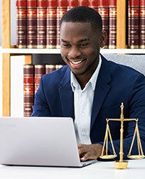 paralegal using laptop at desk.