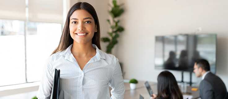paralegal with folder standing in office.