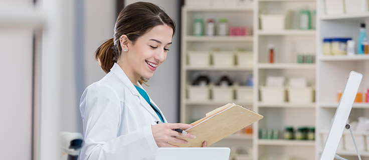 pharmacy technician reading chart in pharmacy.