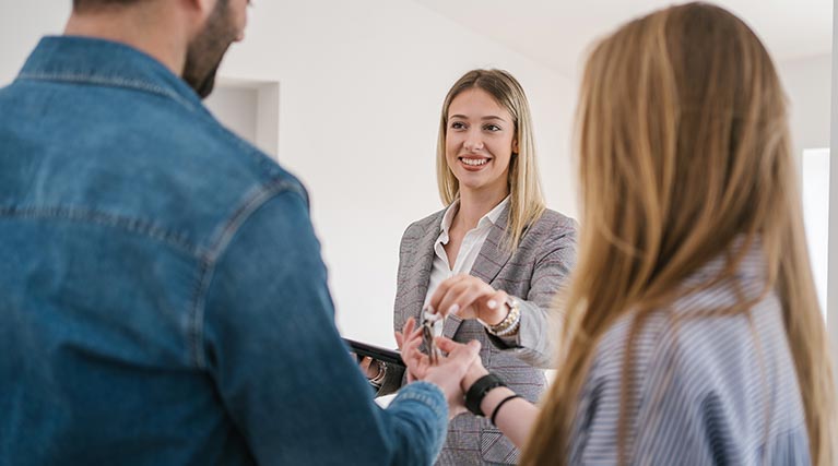 property manager handing keys to new tenants.