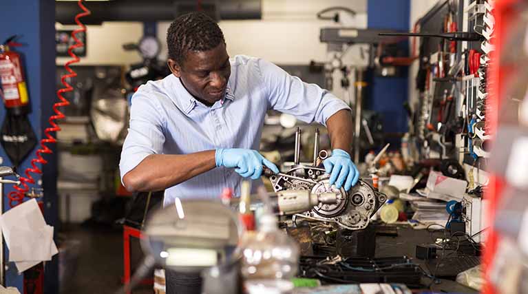 mechanic repairing a small engine in a repair shop.