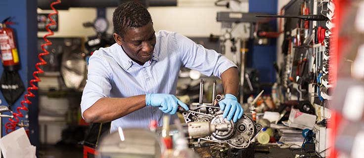 mechanic repairing a small engine in a repair shop.