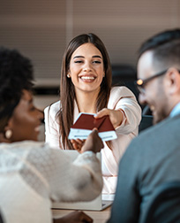 travel agent handing passports and tickets to couple.
