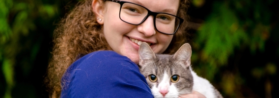 Penn Foster Vet Tech student taking photo with multi-colored cat.