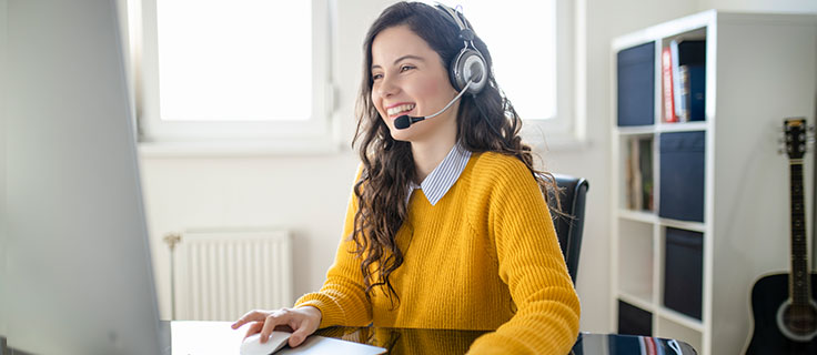 virtual assistant with headset works at her desk.